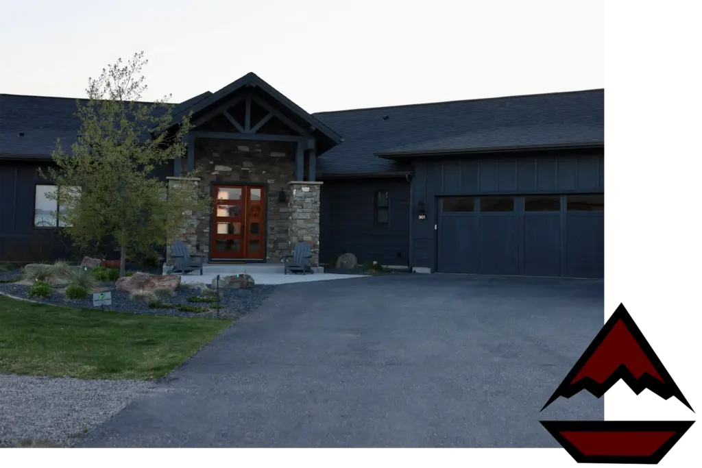 Front entrance of a modern stone-and-blue siding house with a red door and a peaked porch roof.